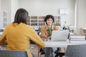 two women in library or coworking are sitting oppo 2022 12 18 18 49 30 utc